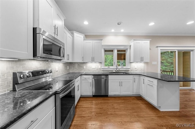 11499 Jack Ln, Hanover, VA 23146 - kitchen featuring stainless steel appliances, a peninsula, healthy amount of natural light, white cabinets, and crown molding