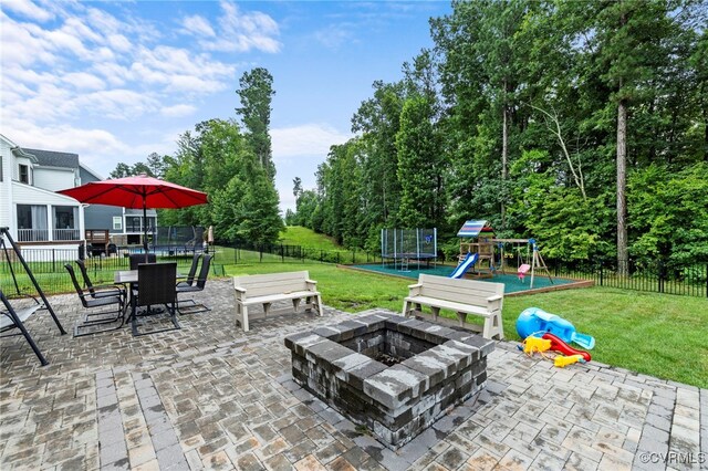 16507 Hannington Dr, Midlothian, VA 23112 - fenced backyard featuring a trampoline, a playground, a patio, outdoor dining space, and a fire pit