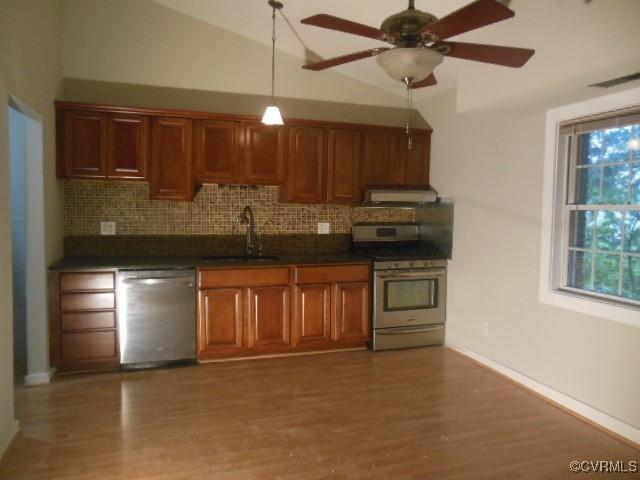 5220 Castlewood Rd Unit E, Chesterfield, VA 23234 - kitchen with stainless steel appliances, under cabinet range hood, dark countertops, decorative backsplash, and vaulted ceiling