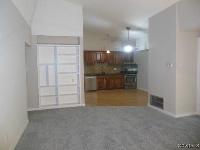 5220 Castlewood Rd Unit E, Chesterfield, VA 23234 - kitchen featuring stainless steel appliances, dark countertops, light colored carpet, tasteful backsplash, and brown cabinets