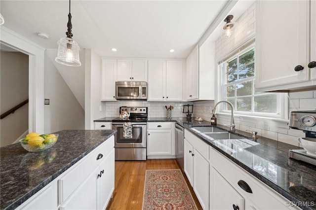 4619 Otterdale Rd, Moseley, VA 23120 - kitchen featuring stainless steel appliances, white cabinets, pendant lighting, decorative backsplash, and light wood-style flooring