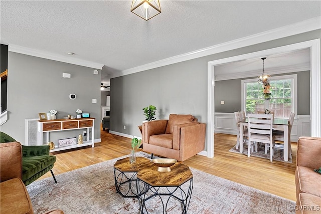 5019 Misty Spring Dr, Midlothian, VA 23112 - living room featuring crown molding, wood finished floors, a textured ceiling, a fireplace, and a wainscoted wall