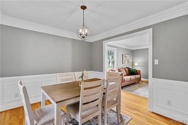 5019 Misty Spring Dr, Midlothian, VA 23112 - dining space featuring a chandelier, crown molding, light wood-style floors, wainscoting, and a decorative wall