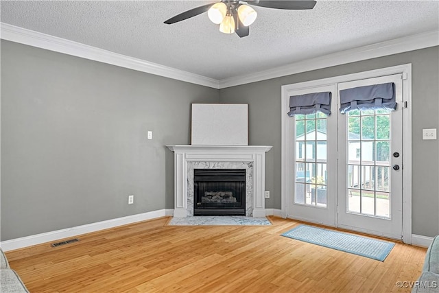 5019 Misty Spring Dr, Midlothian, VA 23112 - unfurnished living room featuring light wood finished floors, crown molding, a ceiling fan, a textured ceiling, and a fireplace