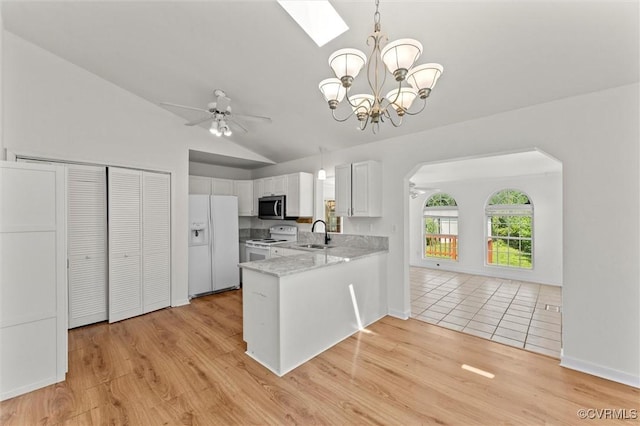 7470 Old Grove Gln, Mechanicsville, VA 23111 - kitchen featuring white appliances, lofted ceiling, arched walkways, a peninsula, and a chandelier