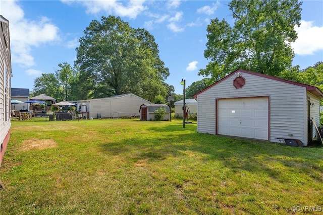 1007 Bolton Rd, Richmond, VA 23225 - view of green lawn featuring an outdoor structure and a garage