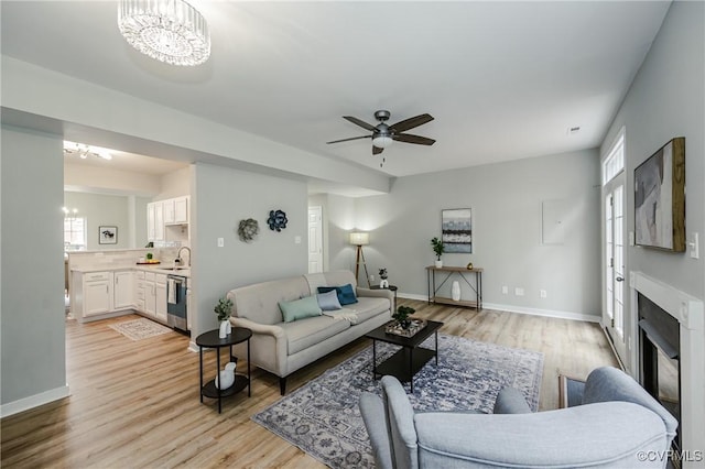11405 Friars Walk Ct, Glen Allen, VA 23059 - living area with light wood finished floors, a chandelier, a ceiling fan, and a glass covered fireplace