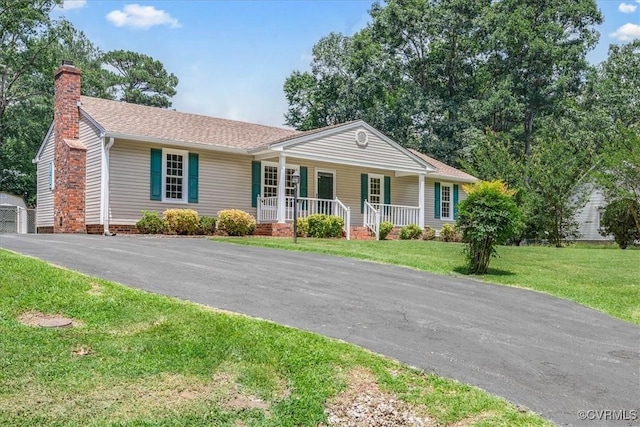 1915 Bogese Dr, Petersburg, VA 23805 - ranch-style house featuring a porch, a chimney, a front yard, and a shingled roof