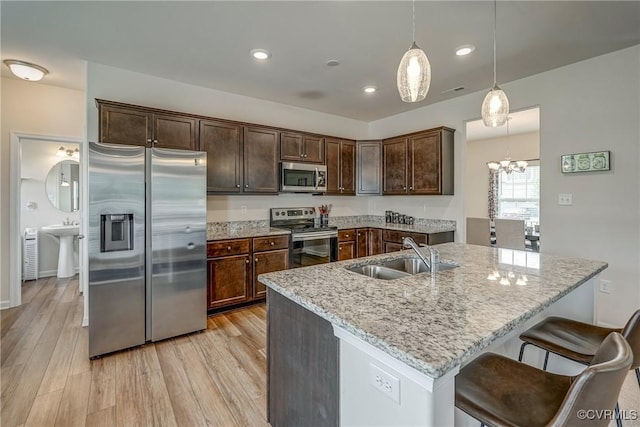 6989 Sir Galahad Rd, Henrico, VA 23231 - kitchen with appliances with stainless steel finishes, dark brown cabinetry, light wood-style floors, light stone counters, and recessed lighting