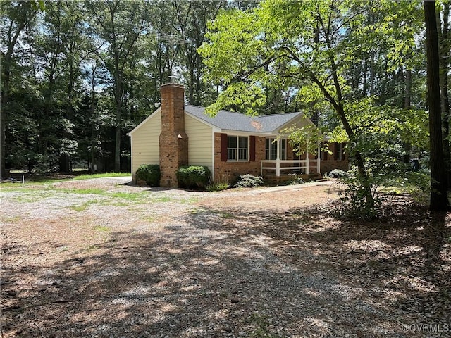 15609 Rowlett Rd, Chesterfield, VA 23838 - view of side of property featuring a chimney, brick siding, and covered porch