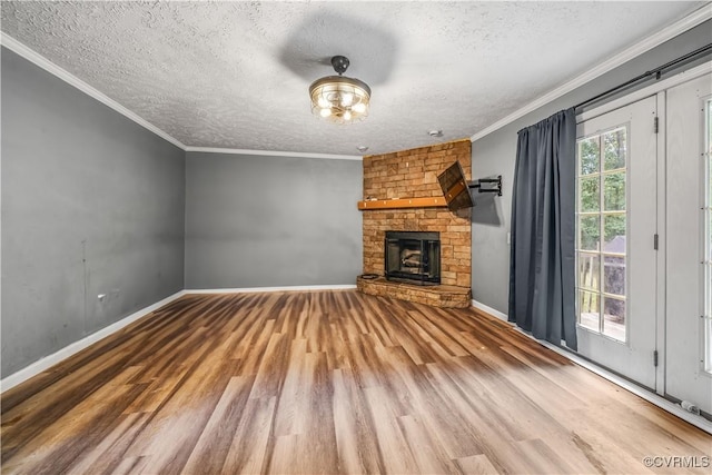 566 Will Johnson Rd, Louisa, VA 23093 - unfurnished living room with a textured ceiling, wood finished floors, a stone fireplace, and crown molding