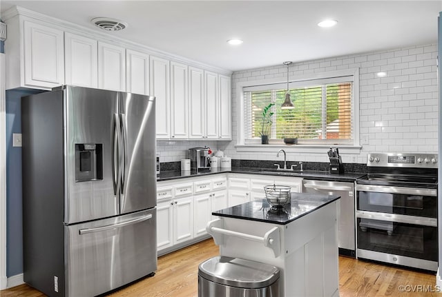 8314 Erma Ln, Richmond, VA 23229 - kitchen featuring appliances with stainless steel finishes, white cabinetry, decorative backsplash, light wood-style flooring, and recessed lighting