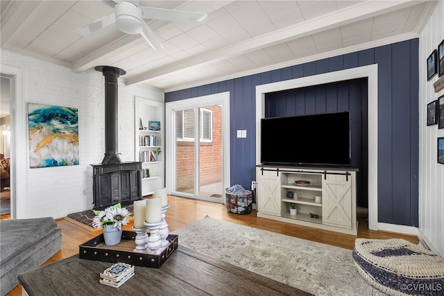 8314 Erma Ln, Richmond, VA 23229 - living area with wood finished floors, beam ceiling, a wood stove, and a ceiling fan