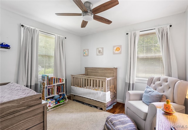 8314 Erma Ln, Richmond, VA 23229 - bedroom with multiple windows, wood finished floors, a ceiling fan, and a nursery area