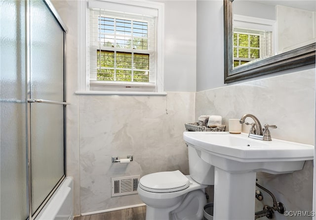 8314 Erma Ln, Richmond, VA 23229 - bathroom with tile walls, combined bath / shower with glass door, and wood finished floors