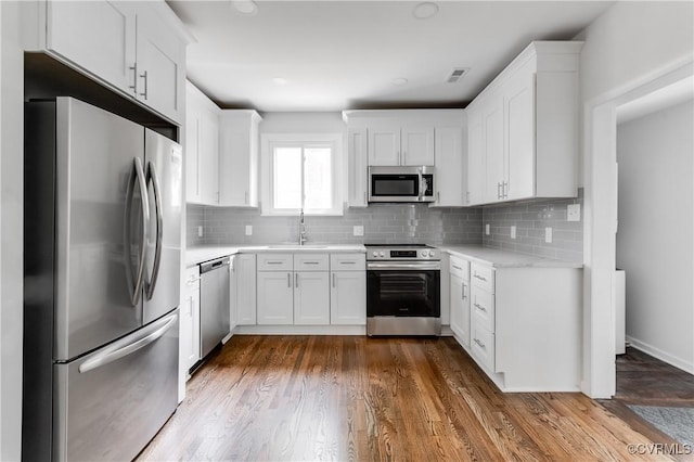 1409 Virginia Ave, Glen Allen, VA 23060 - kitchen featuring stainless steel appliances, light countertops, white cabinetry, and decorative backsplash