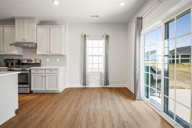 7653 Autumn Leaves Ln, New Kent, VA 23124 - kitchen with stainless steel gas range, under cabinet range hood, light wood-style floors, light countertops, and tasteful backsplash