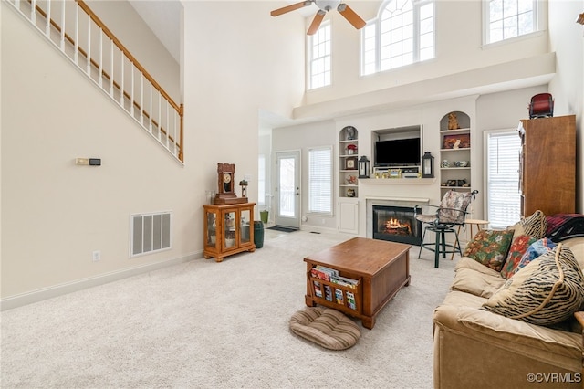 14313 Woodleigh Dr, Chester, VA 23831 - living room featuring a high ceiling, a glass covered fireplace, ceiling fan, built in features, and plenty of natural light