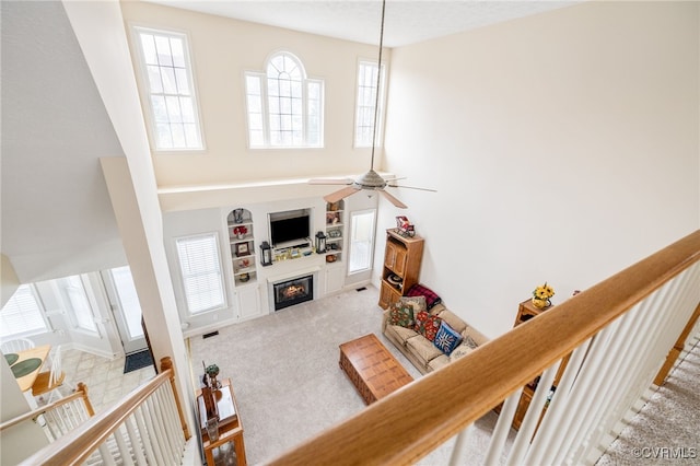 14313 Woodleigh Dr, Chester, VA 23831 - carpeted living area featuring a high ceiling, a glass covered fireplace, a ceiling fan, and built in features