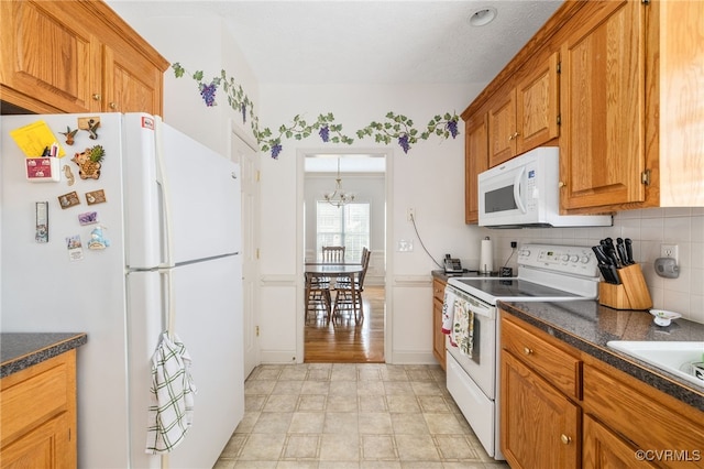 14313 Woodleigh Dr, Chester, VA 23831 - kitchen with white appliances, dark countertops, tasteful backsplash, a chandelier, and brown cabinets