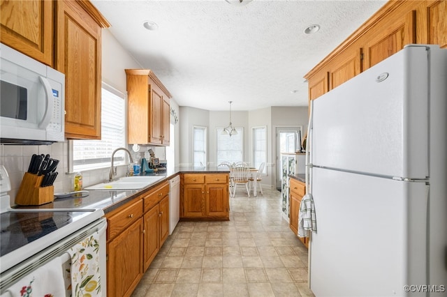 14313 Woodleigh Dr, Chester, VA 23831 - kitchen featuring white appliances, a peninsula, tasteful backsplash, brown cabinets, and dark countertops