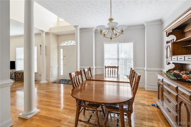 14313 Woodleigh Dr, Chester, VA 23831 - dining space with decorative columns, healthy amount of natural light, a textured ceiling, light wood-type flooring, and ornamental molding