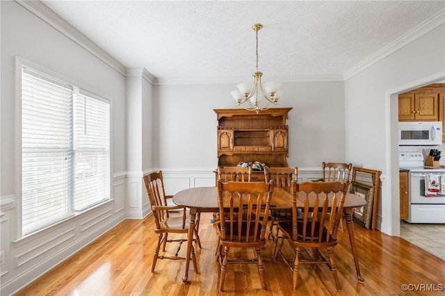 14313 Woodleigh Dr, Chester, VA 23831 - dining area with a chandelier, light wood-type flooring, wainscoting, ornamental molding, and a textured ceiling