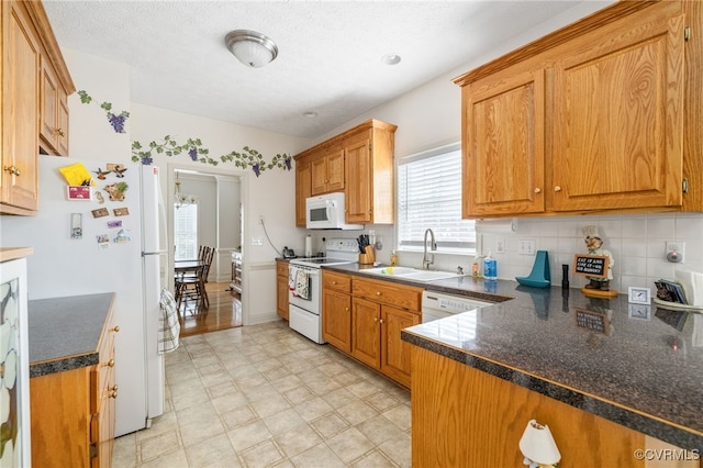 14313 Woodleigh Dr, Chester, VA 23831 - kitchen with white appliances, dark countertops, backsplash, and brown cabinets