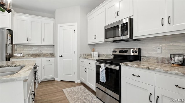5080 Brandon Pines Way, Providence Forge, VA 23140 - kitchen featuring stainless steel appliances, light wood-type flooring, backsplash, white cabinets, and light stone countertops