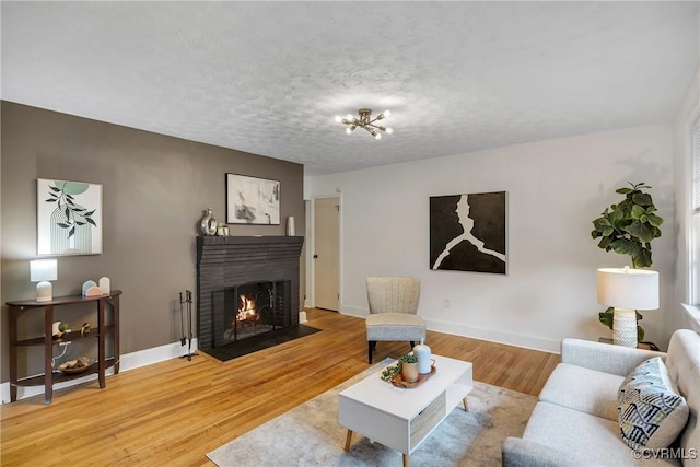520 Heth Rd, Petersburg, VA 23805 - living room featuring a brick fireplace, wood finished floors, and a chandelier