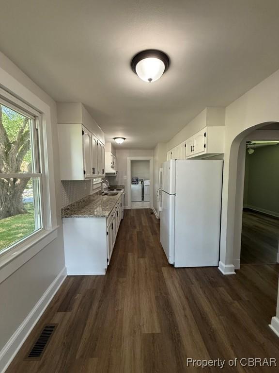 36 Roseneath Ave, Kilmarnock, VA 22482 - kitchen featuring freestanding refrigerator, white cabinetry, dark wood finished floors, and arched walkways