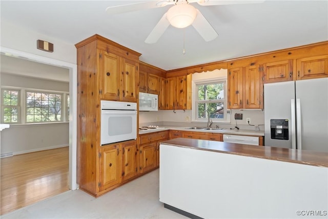 2411 Colwyn Rd, Henrico, VA 23229 - kitchen featuring white appliances, brown cabinets, light countertops, and a ceiling fan