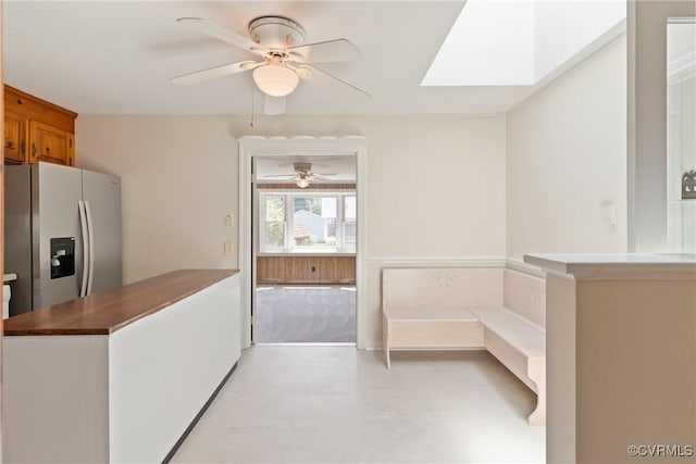 2411 Colwyn Rd, Henrico, VA 23229 - kitchen featuring stainless steel fridge, ceiling fan, a skylight, and brown cabinets