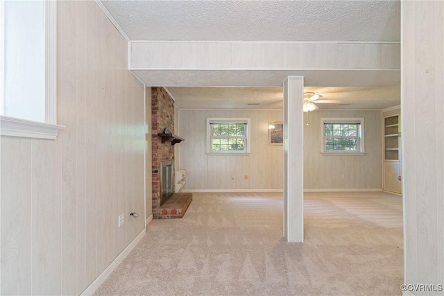 2411 Colwyn Rd, Henrico, VA 23229 - unfurnished living room featuring a textured ceiling, carpet, a fireplace, plenty of natural light, and wooden walls
