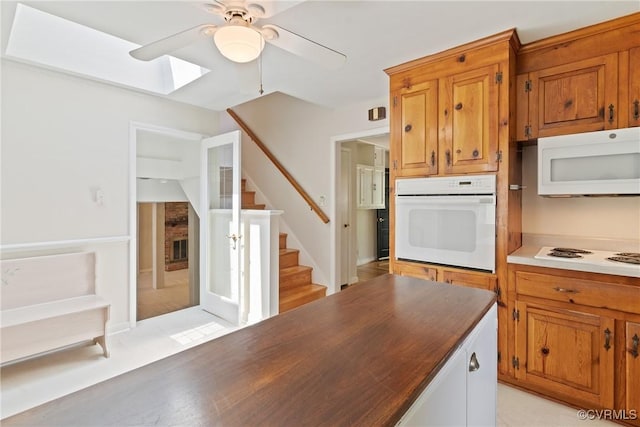 2411 Colwyn Rd, Henrico, VA 23229 - kitchen featuring white appliances, a ceiling fan, a skylight, and brown cabinetry