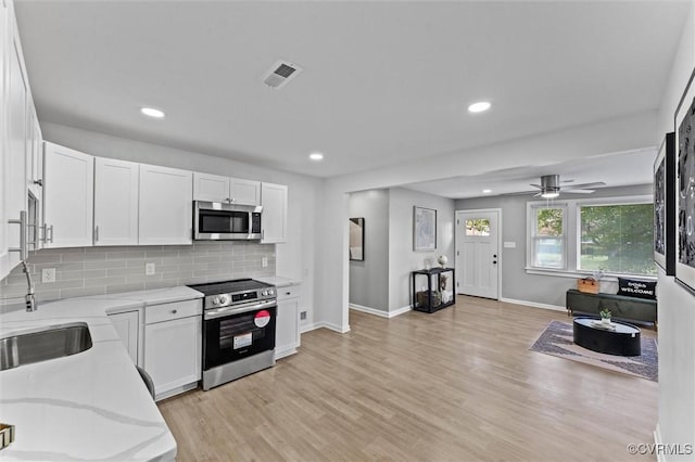 2000 Cleary Rd, Richmond, VA 23223 - kitchen featuring stainless steel appliances, white cabinets, light stone countertops, light wood finished floors, and recessed lighting