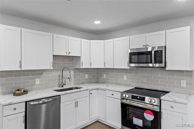 2000 Cleary Rd, Richmond, VA 23223 - kitchen with appliances with stainless steel finishes, white cabinets, light stone countertops, decorative backsplash, and recessed lighting