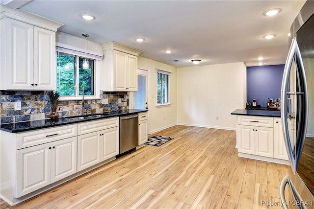 107 Ward, Hampton, VA 23669 - kitchen featuring appliances with stainless steel finishes, tasteful backsplash, light wood-style floors, decorative light fixtures, and white cabinets