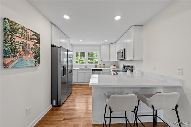 2207 Craven Ln, Henrico, VA 23228 - kitchen with stainless steel appliances, a peninsula, a kitchen bar, recessed lighting, and light countertops