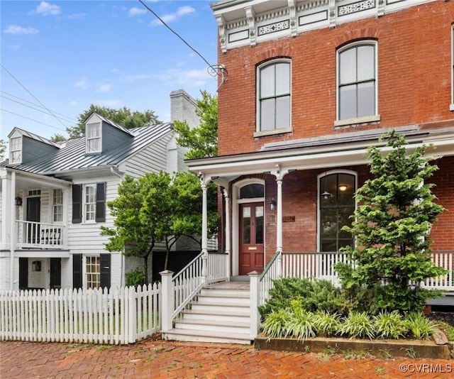 2502 E Grace St, Richmond, VA 23223 - view of front of house with brick siding, covered porch, a standing seam roof, and a metal roof