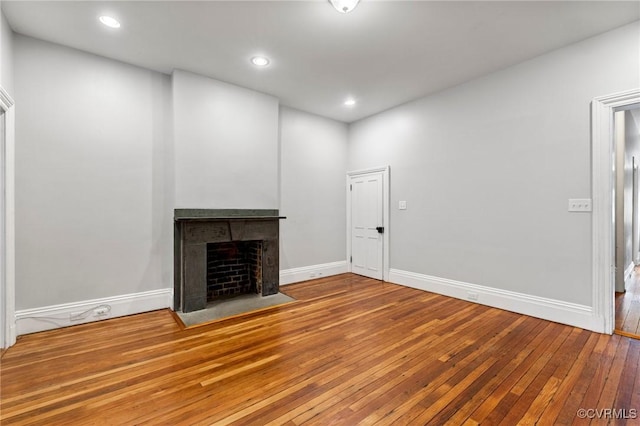 2502 E Grace St, Richmond, VA 23223 - unfurnished living room featuring hardwood / wood-style flooring, a fireplace with flush hearth, and recessed lighting