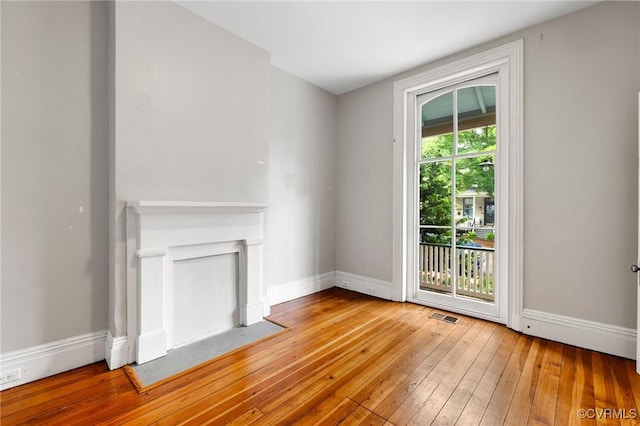 2502 E Grace St, Richmond, VA 23223 - unfurnished living room with hardwood / wood-style floors and baseboards