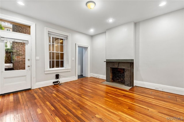 2502 E Grace St, Richmond, VA 23223 - unfurnished living room featuring a fireplace with flush hearth, wood-type flooring, and recessed lighting