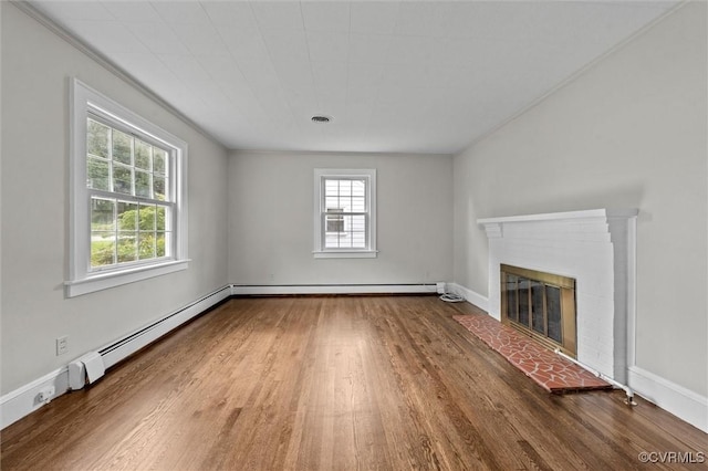 914 Kensington Ave, Colonial Heights, VA 23834 - unfurnished living room featuring healthy amount of natural light, a baseboard heating unit, wood finished floors, and a brick fireplace