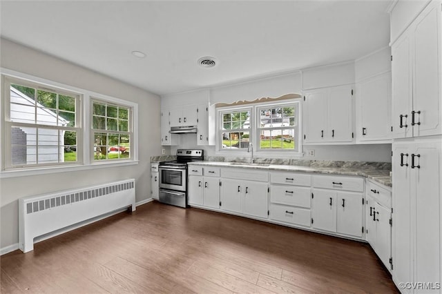 914 Kensington Ave, Colonial Heights, VA 23834 - kitchen featuring stainless steel electric stove, radiator heating unit, under cabinet range hood, white cabinets, and dark wood-type flooring