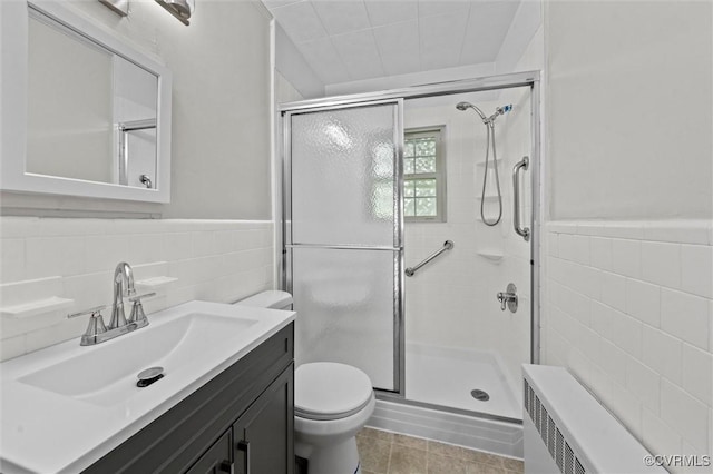 914 Kensington Ave, Colonial Heights, VA 23834 - full bathroom with tile walls, a shower stall, vanity, radiator heating unit, and tile patterned flooring