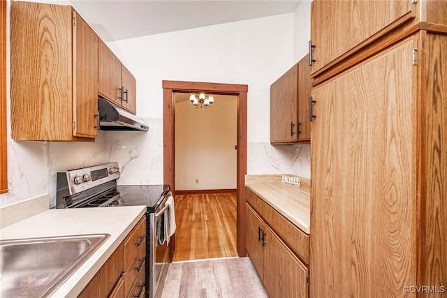 6631 Rural Point Rd, Mechanicsville, VA 23116 - kitchen with under cabinet range hood, stainless steel electric range oven, light wood-style flooring, light countertops, and tasteful backsplash
