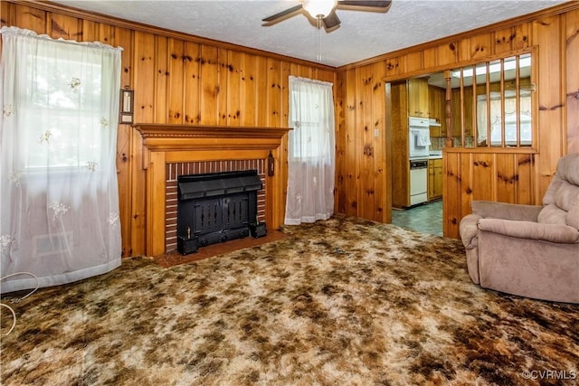 12100 Brookview Dr, Chesterfield, VA 23112 - carpeted living room featuring ceiling fan, crown molding, wood walls, a fireplace, and a textured ceiling