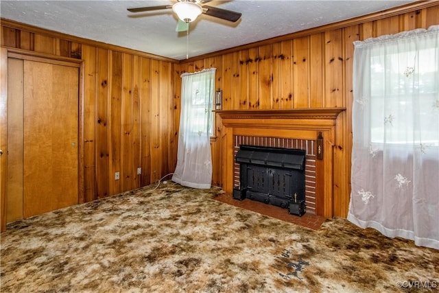 12100 Brookview Dr, Chesterfield, VA 23112 - unfurnished living room featuring a brick fireplace, ceiling fan, wooden walls, crown molding, and carpet floors