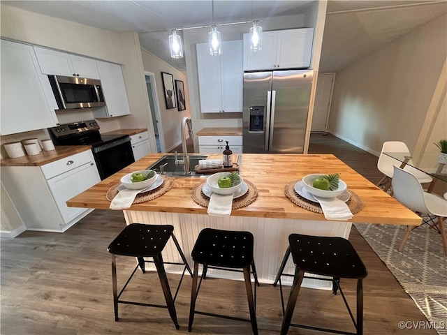 5225 Hopewell Rd, New Kent, VA 23124 - kitchen featuring appliances with stainless steel finishes, wood counters, white cabinets, and a kitchen bar